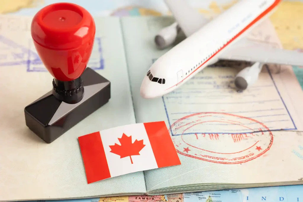 Canadian flag, passport stamp, and toy airplane on a travel document, representing Canada visa approval and international mobility.